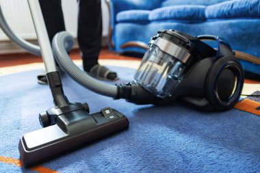 Halıyı elektrikli süpürgeyle temizleyen adam, yakın plan..