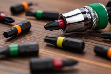 Ahşap arka planda parçaları olan tornavidayı yakından çek..