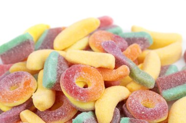 Beyaz arka planda yüzen çeşitli jöle şekerleri.