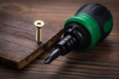 tornavida ve vidalar ahşap arka planda kapat.