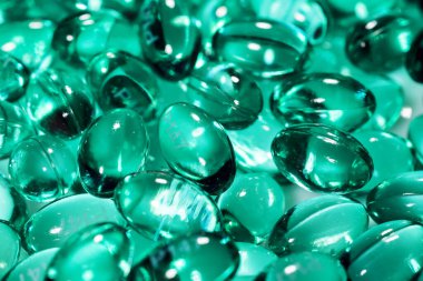 Kabukta sıvı vitaminli mavi kapsüller. Eklem dişleri ve kemikler için beslenme takviyesi içeren mavi kapsüller..