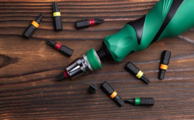 Ahşap arka planda parçaları olan tornavidayı yakından çek..