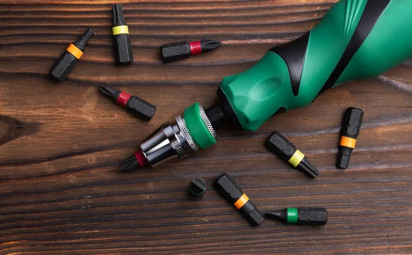 Ahşap arka planda parçaları olan tornavidayı yakından çek..