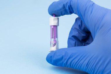 Doktor tek kullanımlık güvenlik kilidi tutuyor. Acısız kan örnekleme için otomatik süsleme cihazı. Parmak ile kan testi. Kan enjeksiyonu