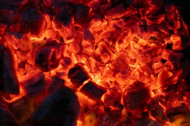 Karanlıkta yanan kömür, yanan kömür. Parlak kırmızı kıvılcımlar. Arkaplan.