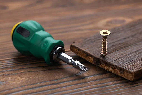 Tornavidayla tahta yüzeye vida takmak. DIY kavramı.