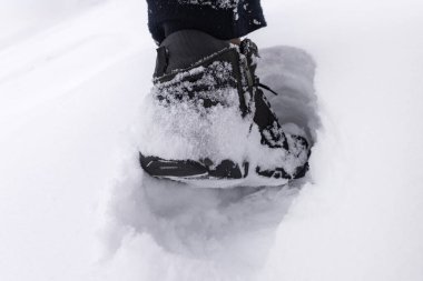 Karda botlar. Çizmeleri karda duran bir adam.