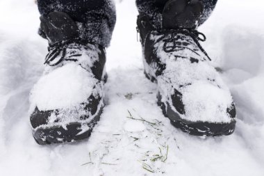 Taze karla kaplı deri yürüyüş botları giyen bir adam kar fırtınasından sonra açık havada kar yürüyüşü beyaz buz pateni yapan bir adam.