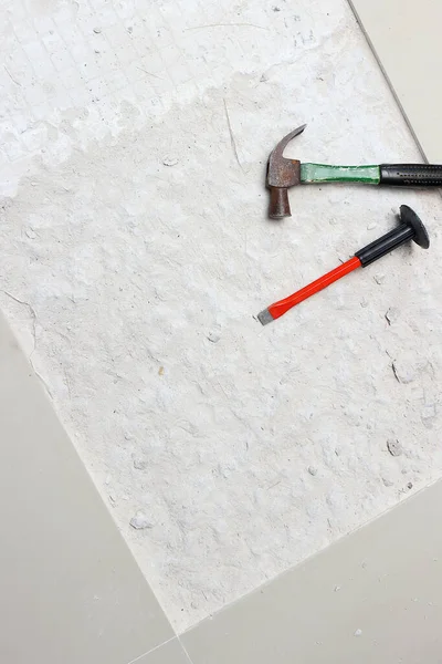 Beton delmek için bir çekiç ve bir keski yeni döşenmiş bölgenin yanına yerleştiriliyor..