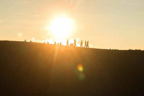 Reizigers Silhouetten Tegen Het Oranje Licht Van Zonsondergang Bergen — Stockfoto