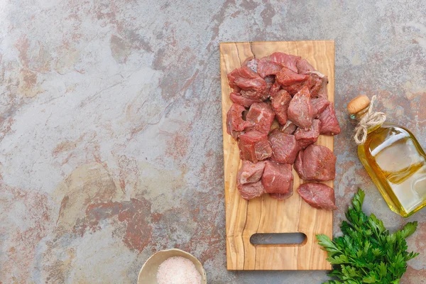 Raw fresh meat cubes on cutting board — Stock Photo, Image