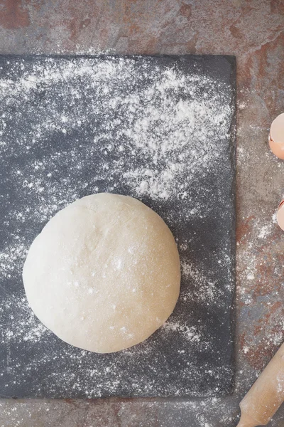 Ball of pastry dough with rolling pin on floured surface — Stock Photo, Image