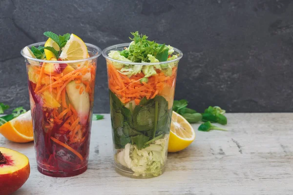 Salade de fruits et légumes disposée dans des tasses en plastique transparent à emporter — Photo