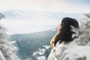 Karlı dağdaki kadın portresi. Sabah güneşinde kar kaplı dağın önünde duran kadın. Seçici odak, boşluğu kopyala