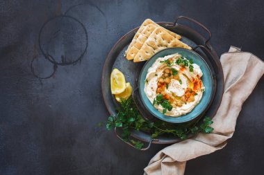 Lezzetli ev yapımı nohut humusu üzerine nohut ve maydanoz serpiştirilmiş pita ekmeği. Üst görünüm, boş boşluk
