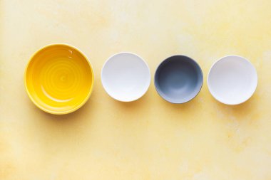 Kırsal sarı yüzeyde çeşitli seramik çok renkli boş kaseler. Üst görünüm, boş boşluk