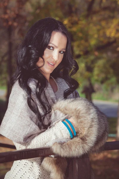 Beautiful elegant woman standing in a park in autumn — Stock Photo, Image