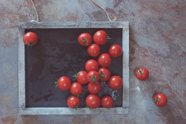 Los tomates frescos de guinda sobre la pizarra —  Fotos de Stock
