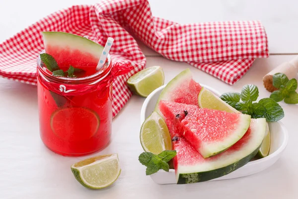 Sumo de melancia em jarra de vidro e cunhas de melancia fresca — Fotografia de Stock