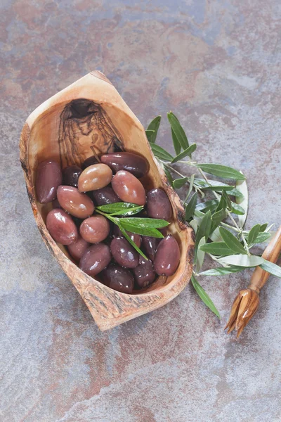 Mixed oily olives in olive wood bowl