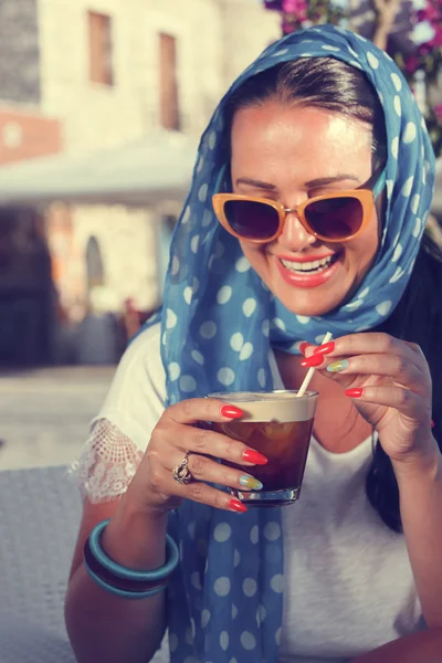 Счастливая молодая женщина пьет холодный кофе в ресторане — стоковое фото