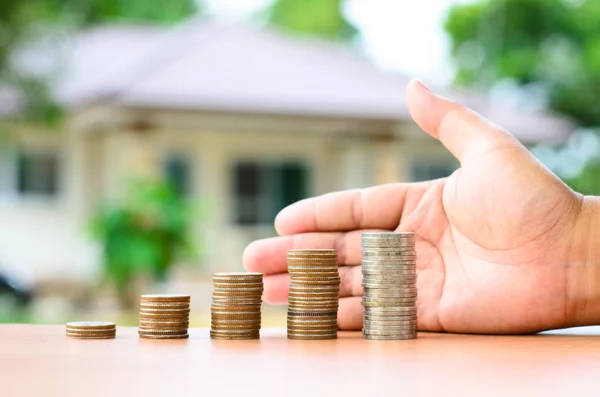 Mannenhand beschermen geld munten stack met huis — Stockfoto