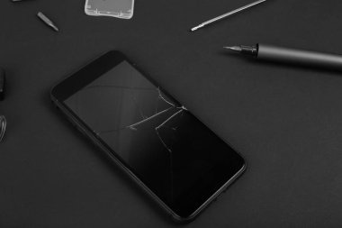 İş yerini telefon ve özel aletlerle onar. Aletleri sökülen ve beyaz arka planda tamirci elleri olan parçalanmış akıllı telefon. Elektronik tamir servisi.