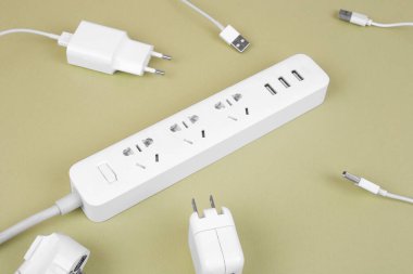 Zeytin zemininde soketleri olan şık beyaz elektrik genişleticisi. Elektrik güç beyaz şeridi ya da uzatma bloğu. Bir sürü kablo ve oyuk. Yüksek teknoloji akıllı şerit. Kapat..