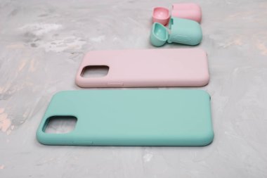 Renkli silikon telefon kılıfları, saat kayışı ve kulaklıklar için çantalar. Hazır ol. Güncel teknoloji. Çok şık. Taş zemin üzerinde duran çeşitli kişisel aksesuarları kapat