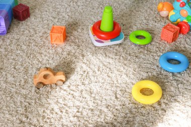 Halıda çocuk oyuncakları var. Küçükler için temel mantık oyuncakları. Piramit, küp, makine