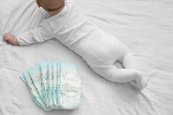 Baby Met Een Stapel Luiers Een Wit Bed Gevoelige Babyhuid — Stockfoto