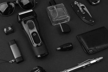 Taş zeminde erkek aksesuarları. Saat, tornavida, bıçak, gözlük, USB çubuk, araba anahtarları, çanta, elektronik sigara, parfüm, elektrikli tıraş makinesi..