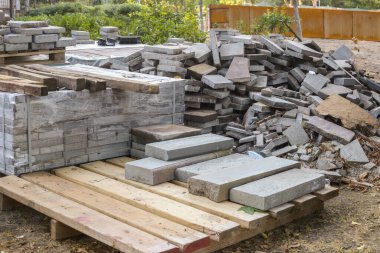 Bir yığın beton kaldırım taşı. Kaldırımı onar ve döşeme levhalarını döşe. Şehir inşaatı için inşaat malzemeleri, kum dolgu. Yol fayansları ve kaldırımlar