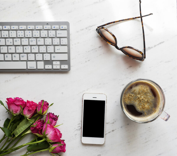 Workplace with smartphone, coffee, keyboard and roses, 