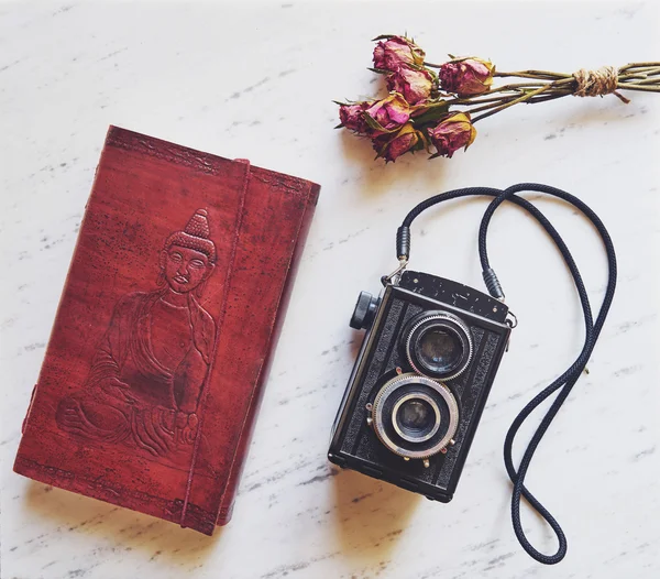 Vintage camera on marble background with  notebook and dried ros — Stock Photo, Image