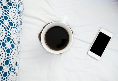 Yatak, dizüstü bilgisayar ve kahve beyaz yatakta çalışma