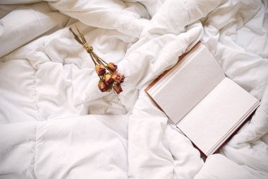 Kuru gül ve yatakta vintage defter