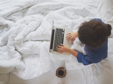 Onun yatağında evde kahve içme ve onu kontrol genç kadın 