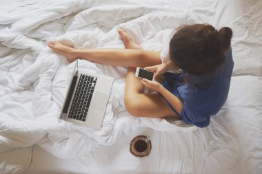 Onun yatağında evde kahve içme ve onu kontrol genç kadın 