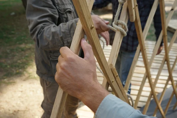 Eller erkek inşaatçılar. Erkekler Asya yurt çerçeve kurmak. — Stok fotoğraf