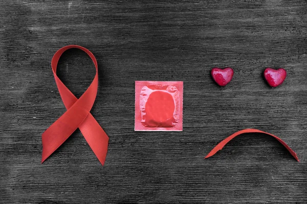 Aids ribbon, kondom och sorgsna ansikte — Stockfoto