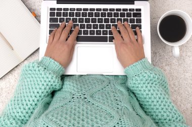 Dizüstü bilgisayar, dizüstü bilgisayar ve bir fincan kahve kızın elinde