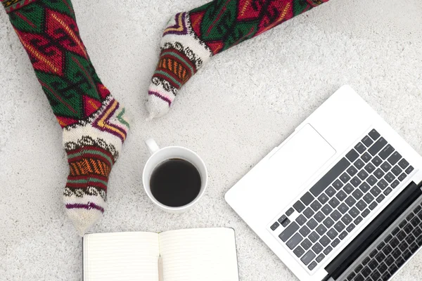 shot of woman feet, laptop, coffee and notebook on the white car