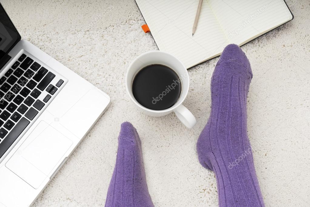 shot of woman feet, laptop, coffee and notebook on the white car