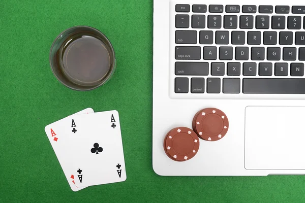 Dizüstü bilgisayar, poker kartları ve poker fişleri