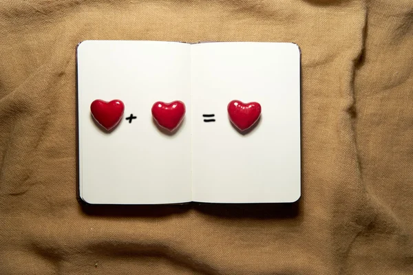 Cuaderno en blanco con corazones sobre fondo de saco — Foto de Stock