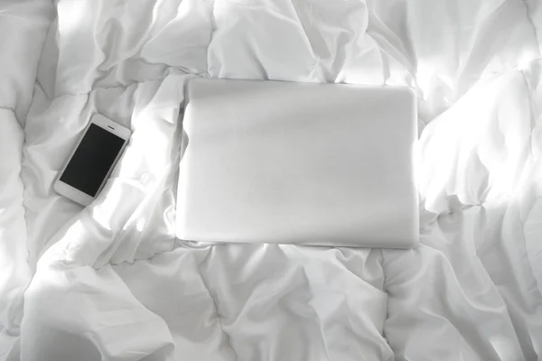 침대, 노트북 및 스마트폰 화이트 침대에서 일 — 스톡 사진