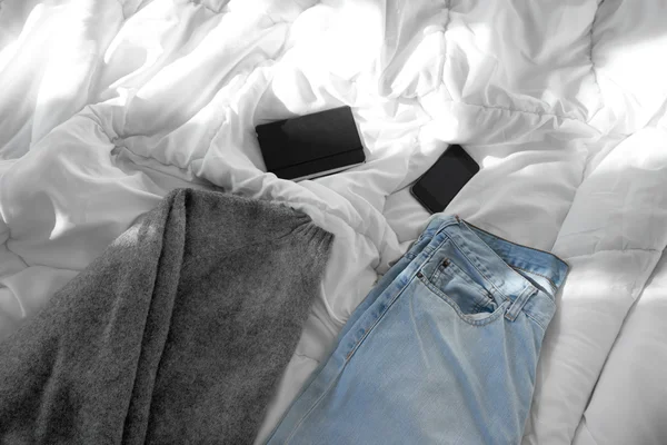 남성 옷, 노트북 및 스마트폰 침대에 — 스톡 사진