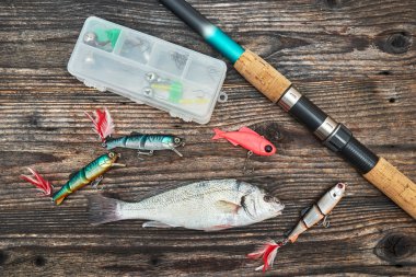 Çubuk iplik, reel ve balıkçılık yemler üzerinde izole ahşap backgrou