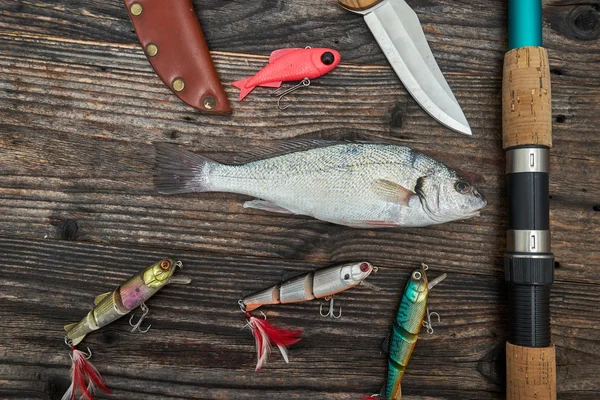 Przędzenia pręt, kołowrotek i połowów przynęty na białym tle na drewniane backgrou — Zdjęcie stockowe